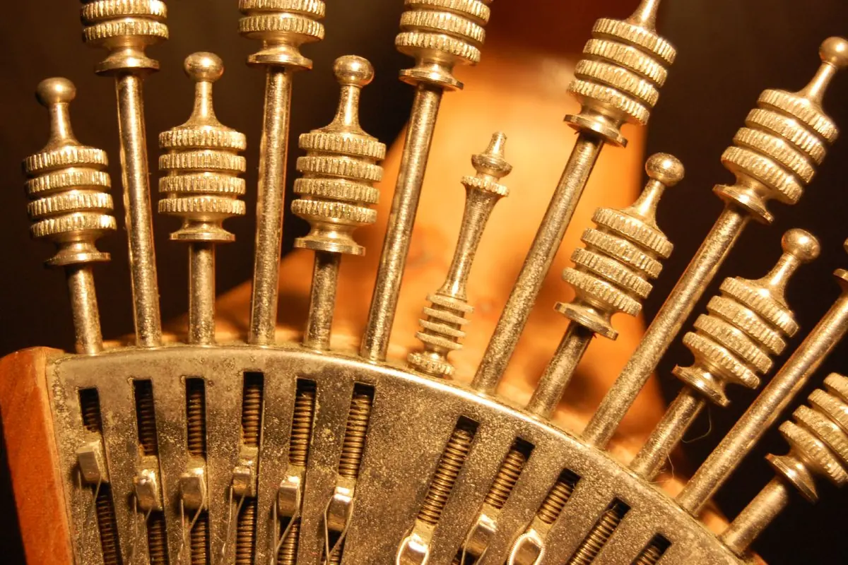 Gold watch-key tuning pegs fanned out on the head of a Portuguese guitar
